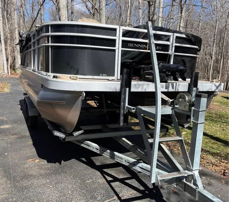 Slide: The Image of 2018 Bennington 21 SFX pontoon boat on trailer in wooded area. - 2