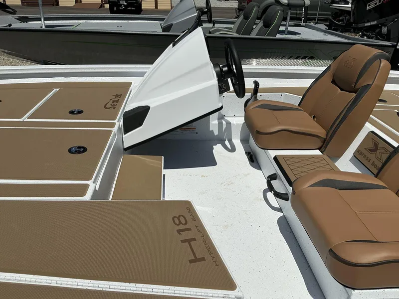 Slide: The Image of 2025 Xpress Hyper-Lift Series H18 bass boat interior with tan seating and console. - 3