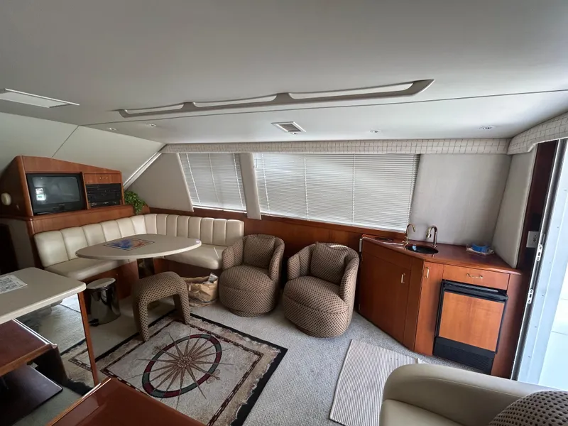 Slide: The Image of Interior of 1995 Ocean Yachts 42 Super Sport with seating, table, and kitchenette. - 12
