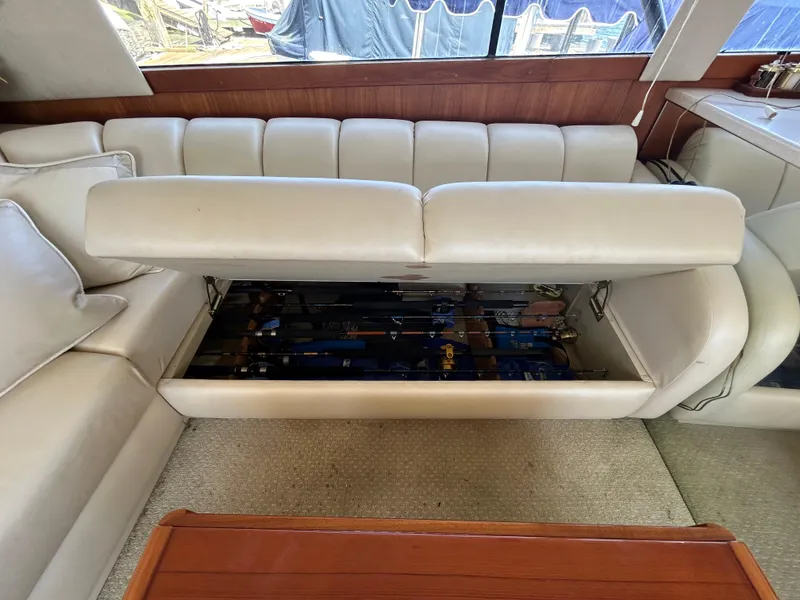 Slide: The Image of 1995 Ocean Yachts 42 Super Sport interior with fishing rod storage under white sofa. - 28