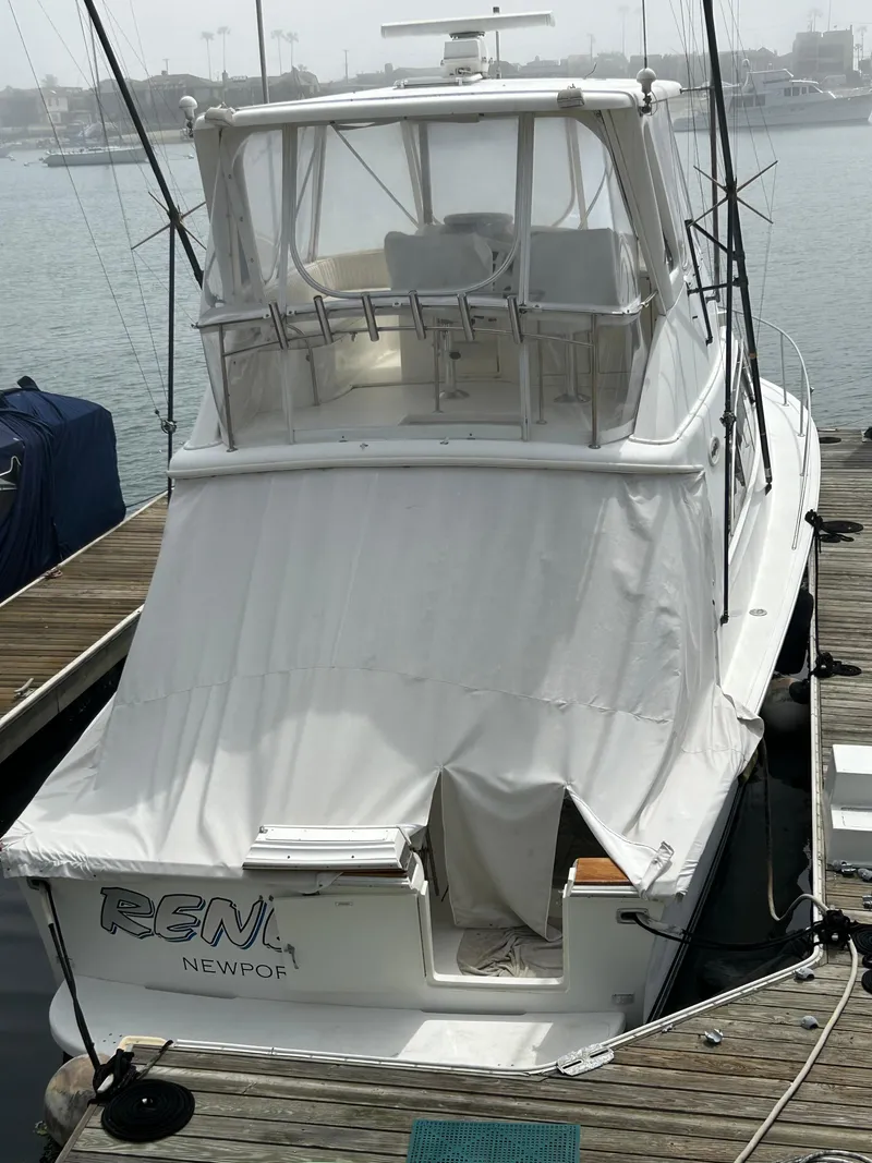 Slide: The Image of 1995 Ocean Yachts 42 Super Sport docked, covered, with fishing rods, in a marina setting. - 4