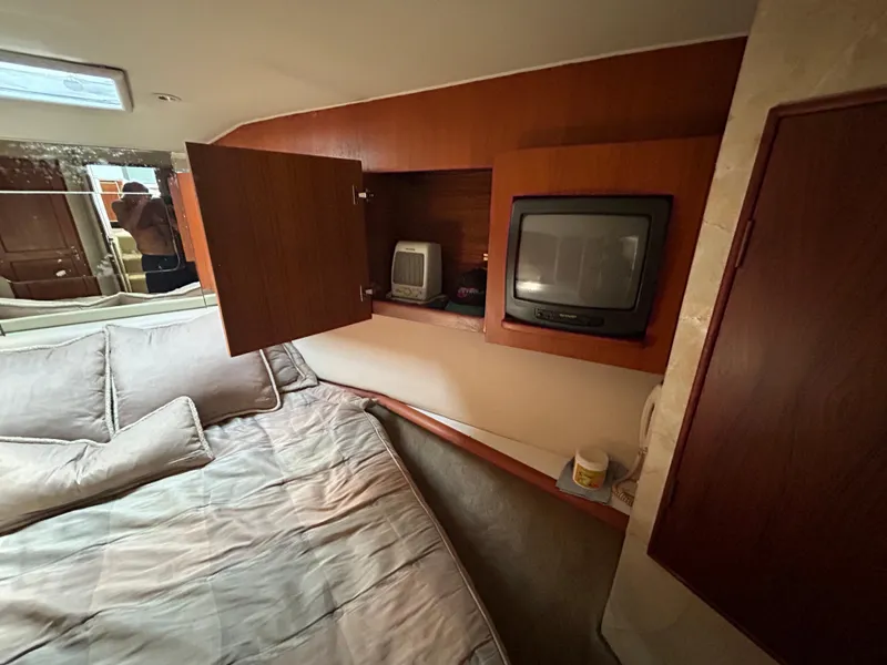 Slide: The Image of 1995 Ocean Yachts 42 Super Sport cabin with bed, TV, and storage cabinets. - 45