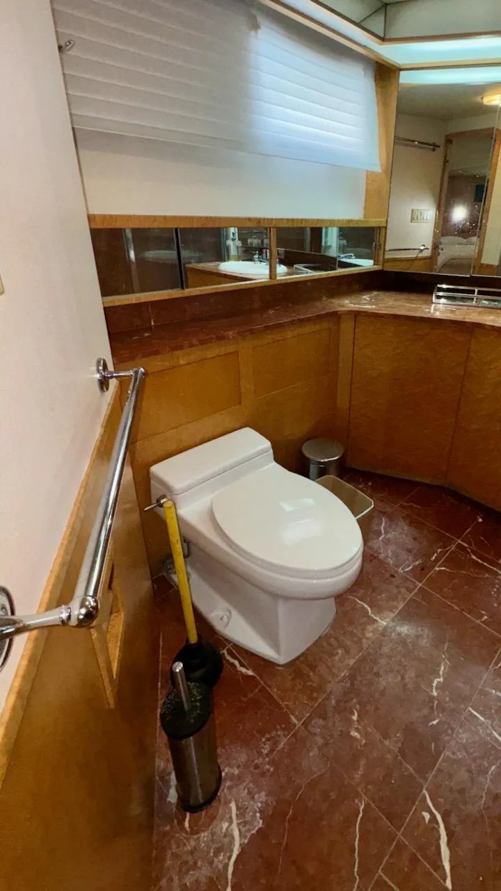Slide: The Image of Luxury yacht bathroom with marble flooring, wooden cabinetry, and modern fixtures on a 1987 Burger 86 Raised Pilothouse. - 11