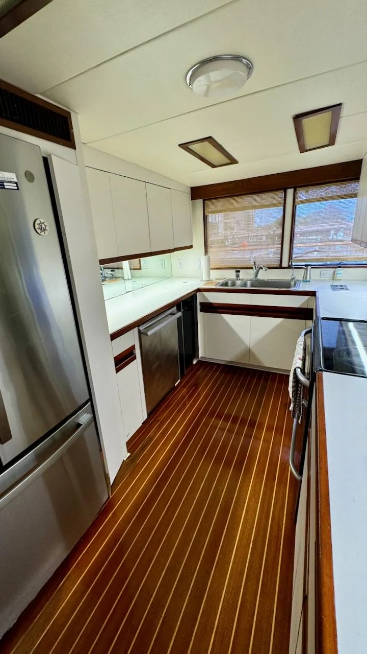 Slide: The Image of Luxurious kitchen interior of 1987 Burger 86 Raised Pilothouse yacht with wood flooring. - 14