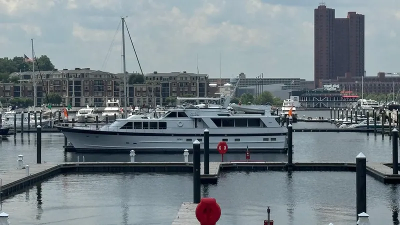 Slide: The Image of 1987 Burger 86 Raised Pilothouse yacht docked in a marina with cityscape background. - 5