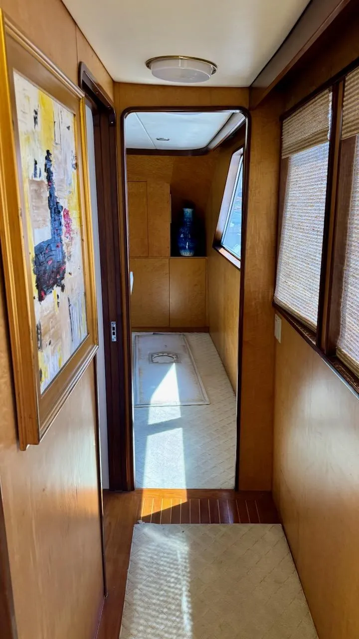 Slide: The Image of Interior hallway of 1987 Burger 86 Raised Pilothouse yacht, featuring wood paneling and artwork. - 9
