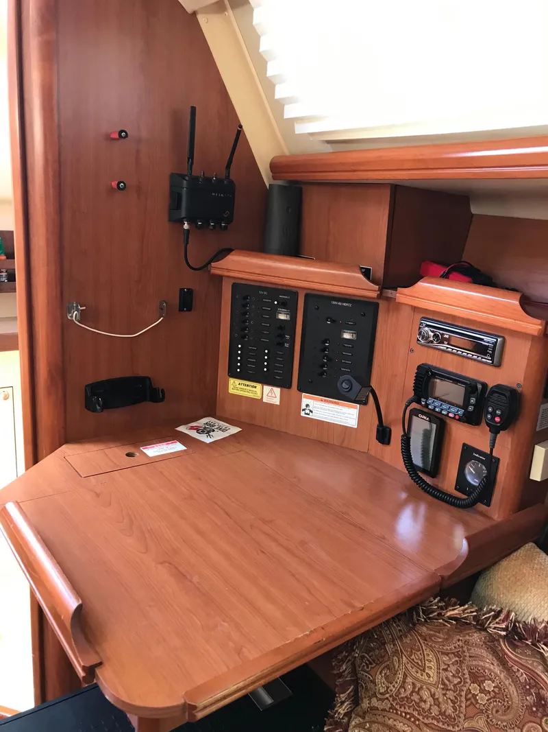 Slide: The Image of 2009 Hunter 310 yacht interior navigation station with control panels and communication equipment. - 16
