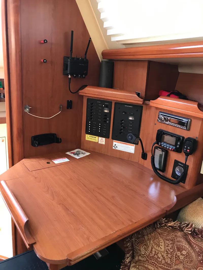 Slide: The Image of 2009 Hunter 310 sailboat navigation station with control panels and communication equipment. - 17