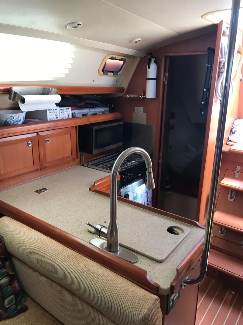 Slide: The Image of Interior of 2009 Hunter 310 sailboat with kitchen and wooden cabinetry. - 18
