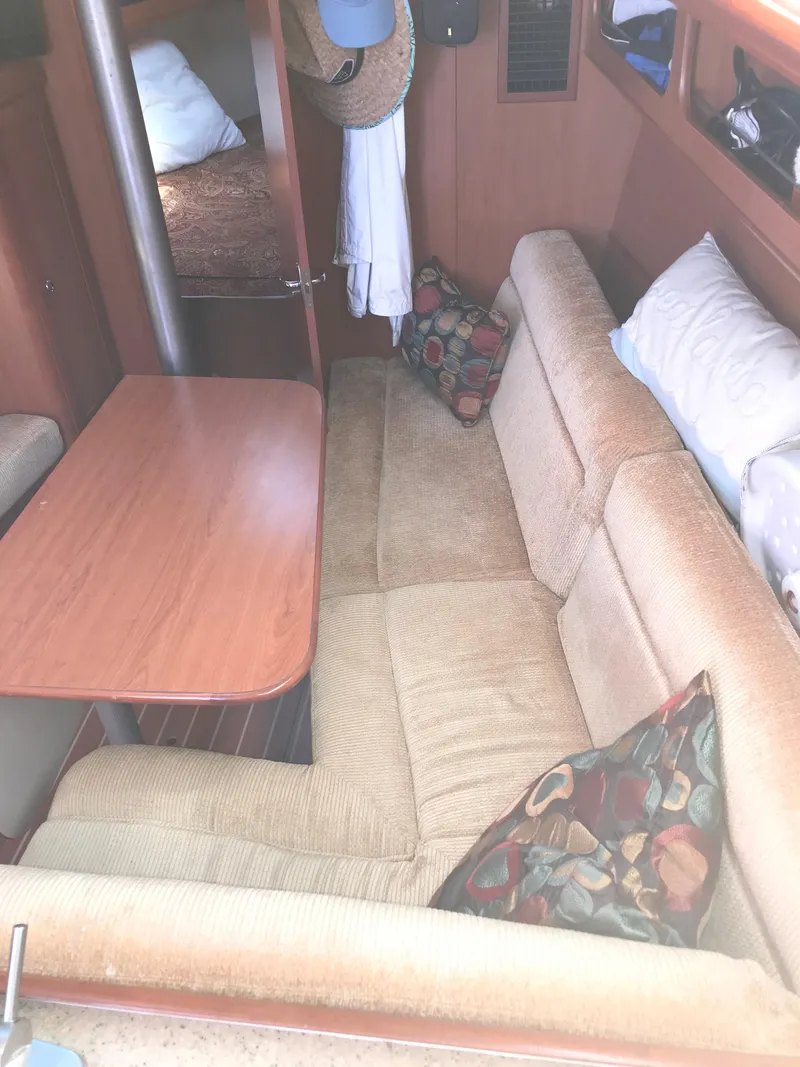 Slide: The Image of Interior of 2009 Hunter 310 sailboat with beige seating and wooden table. - 23