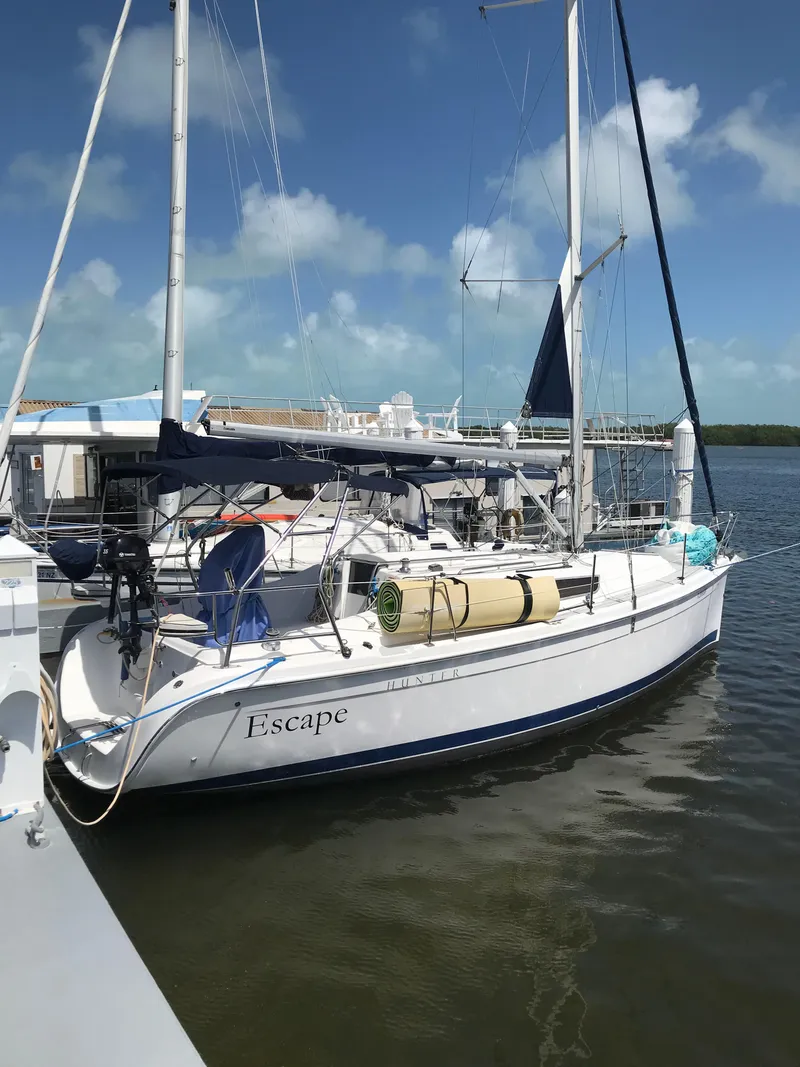 Slide: The Image of 2009 Hunter 310 sailboat docked at marina under clear blue sky. - 26