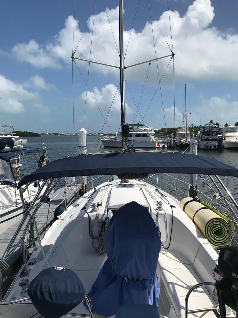 Slide: The Image of 2009 Hunter 310 sailboat docked at marina under blue sky. - 4