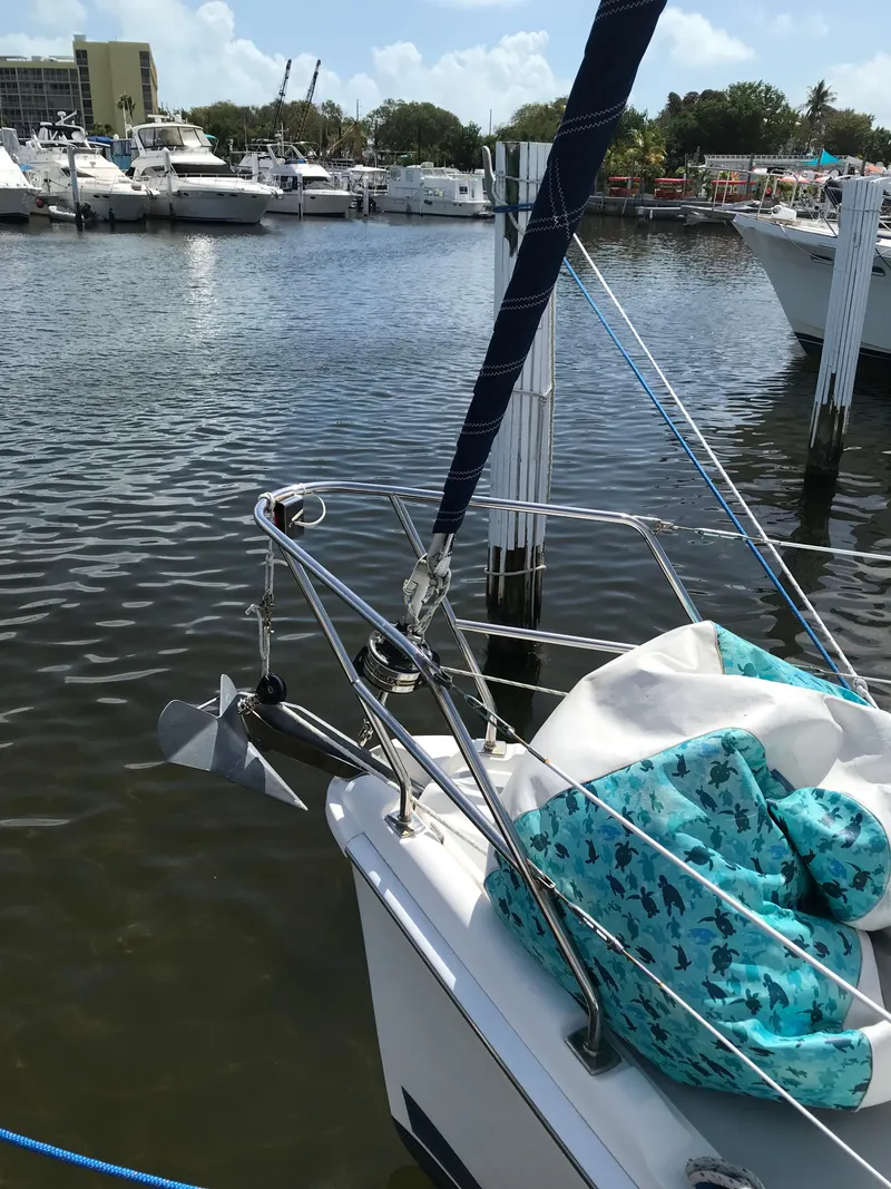 Slide: The Image of 2009 Hunter 310 sailboat docked in a marina with other boats in the background. - 6