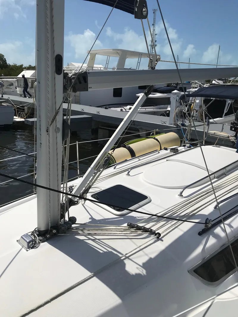 Slide: The Image of 2009 Hunter 310 sailboat docked, featuring rigging and deck details. - 7