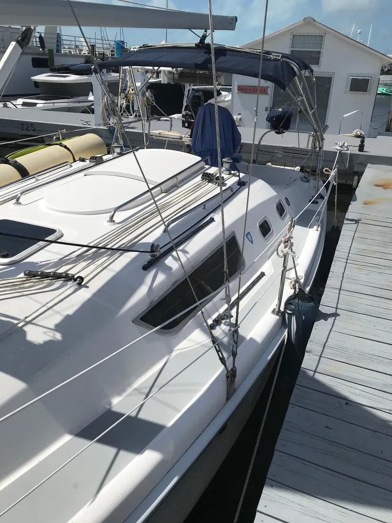 Slide: The Image of 2009 Hunter 310 sailboat docked at marina, featuring sleek design and modern amenities. - 8