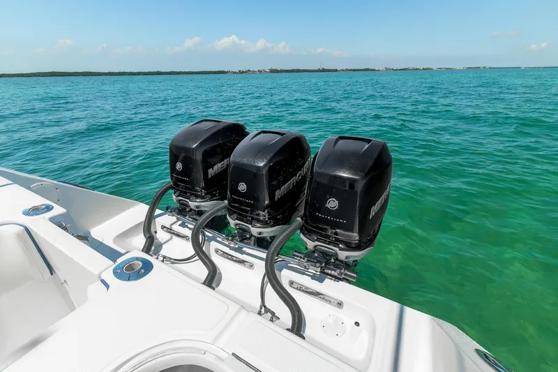 Slide: The Image of Triple outboard motors on a 2017 SeaHunter 35 Tournament boat in clear blue waters. - 11