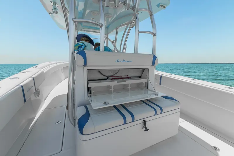 Slide: The Image of 2017 SeaHunter 35 Tournament boat interior with seating and storage, on calm ocean waters. - 18