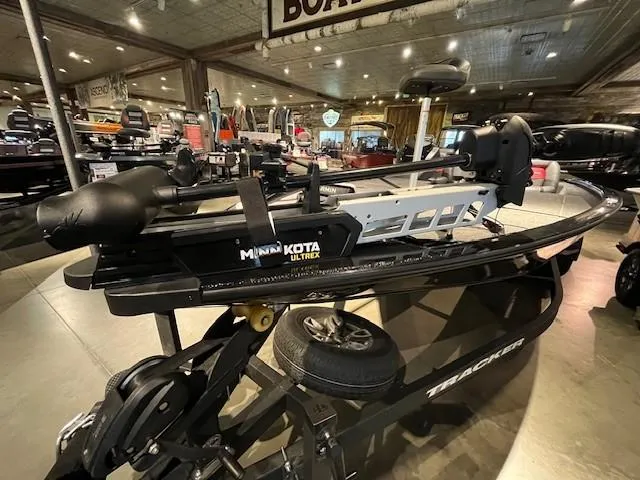 Slide: The Image of 2025 Tracker Savage 215 boat displayed indoors with modern fishing equipment. - 2