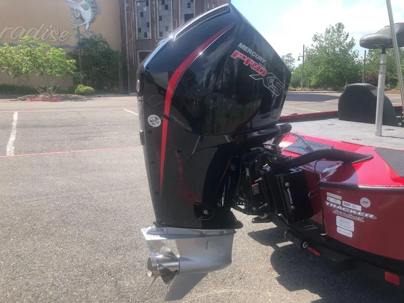 Slide: The Image of 2025 Tracker Savage 215 with Mercury Pro XS outboard motor in a parking lot. - 10