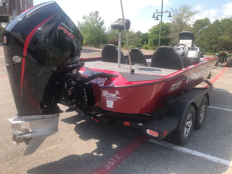 Slide: The Image of 2025 Tracker Savage 215 boat with powerful outboard motor, parked on a trailer. - 11