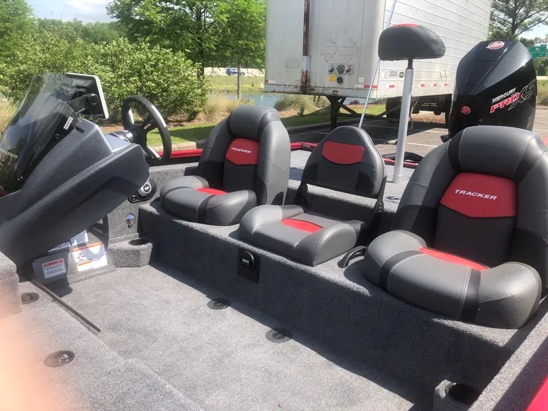 Slide: The Image of 2025 Tracker Savage 215 boat interior with three seats and steering console. - 6