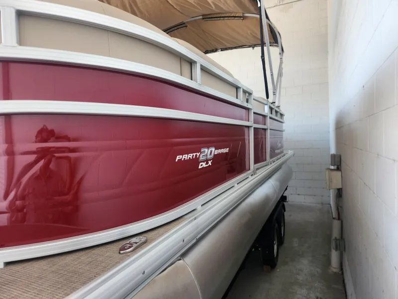 Slide: The Image of 2025 Sun Tracker Party Barge 20 DLX pontoon boat in storage. - 2