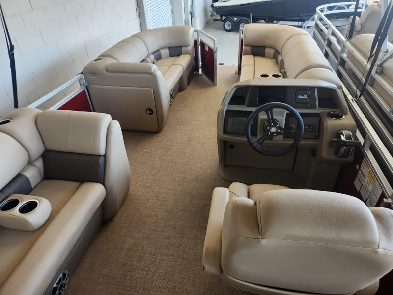 Slide: The Image of 2025 Sun Tracker Party Barge 20 DLX interior with plush seating and steering console. - 5