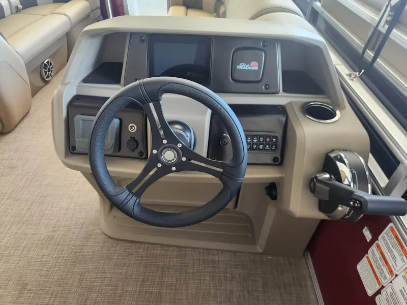 Slide: The Image of 2025 Sun Tracker Party Barge 20 DLX steering console with modern controls and beige interior. - 7