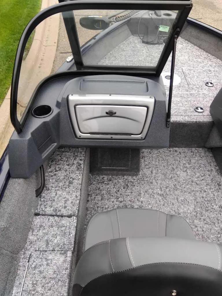 Slide: The Image of 2025 Tracker Pro Guide V-16 WT boat interior with gray seating and storage compartment. - 7