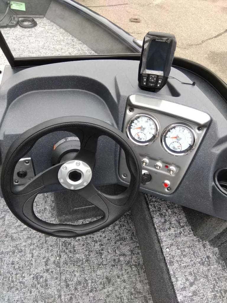 Slide: The Image of 2025 Tracker Pro Guide V-16 WT boat dashboard with steering wheel and gauges. - 8