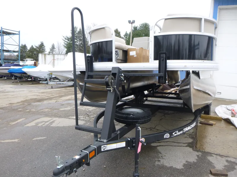 Slide: The Image of 2025 Sun Tracker Party Barge 16 DLX pontoon boat on trailer in outdoor setting. - 3