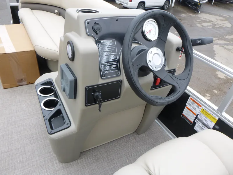Slide: The Image of 2025 Sun Tracker Party Barge 16 DLX steering console with cup holders and gauges. - 6