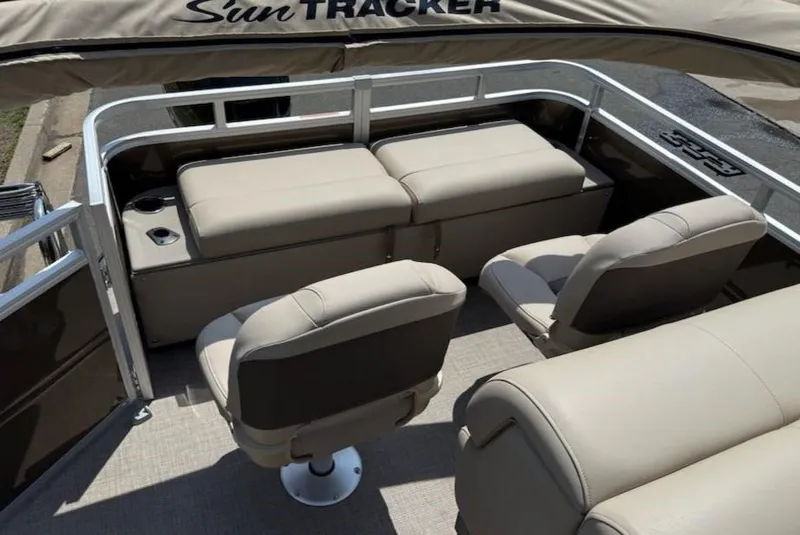 Slide: The Image of 2025 Sun Tracker SportFish 22 DLX pontoon boat interior with beige seating and cup holders. - 4