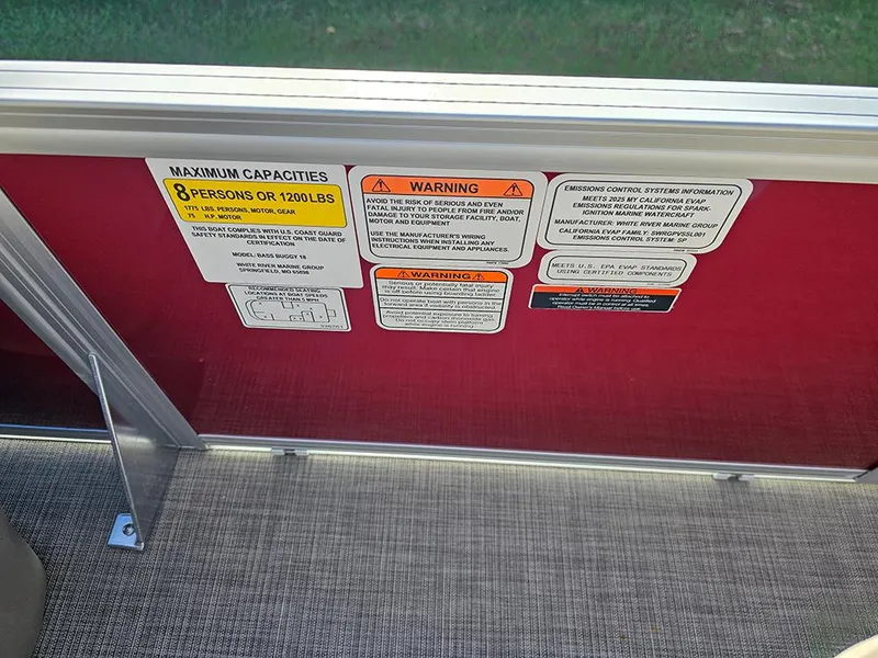 Slide: The Image of 2025 Sun Tracker Bass Buggy 18 DLX capacity and warning labels on red panel. - 16