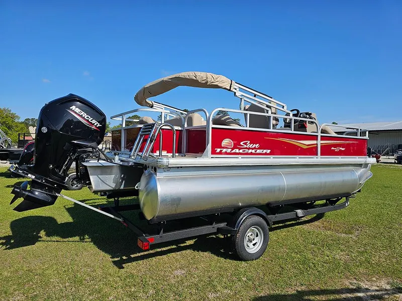 Slide: The Image of 2025 Sun Tracker Bass Buggy 18 DLX pontoon boat on trailer, featuring Mercury outboard motor. - 3