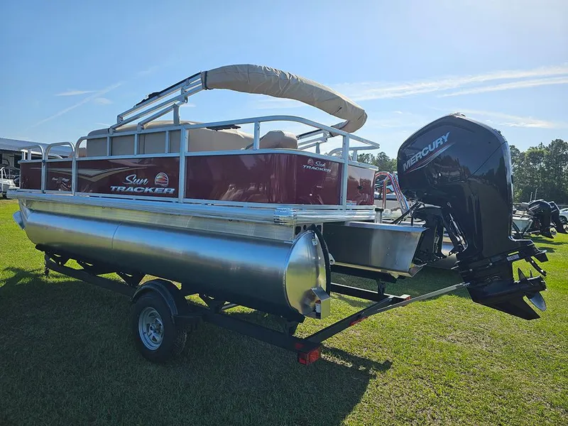 Slide: The Image of 2025 Sun Tracker Bass Buggy 18 DLX pontoon boat with Mercury outboard motor on trailer. - 7