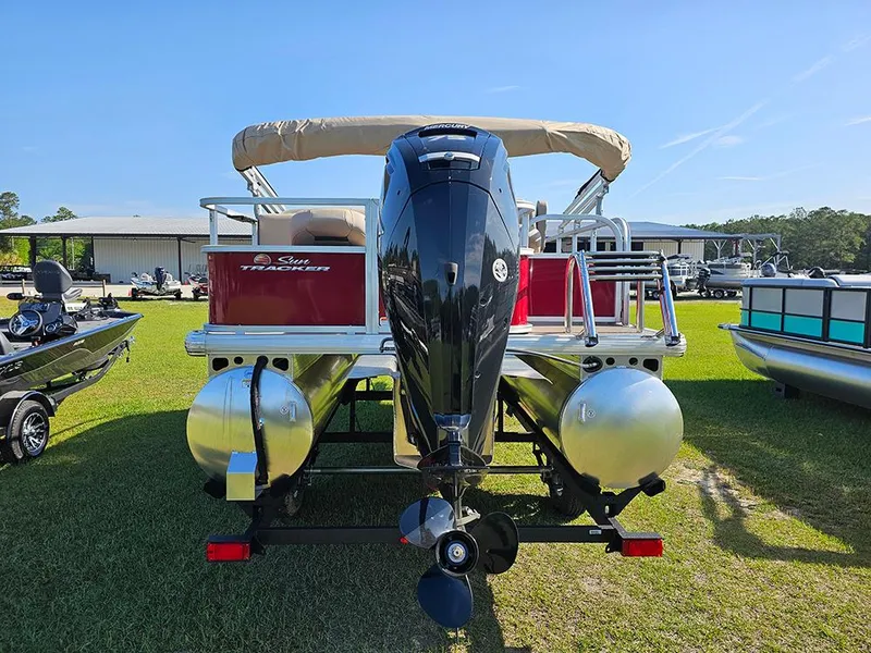 Slide: The Image of 2025 Sun Tracker Bass Buggy 18 DLX pontoon boat, rear view with motor, on grass. - 8