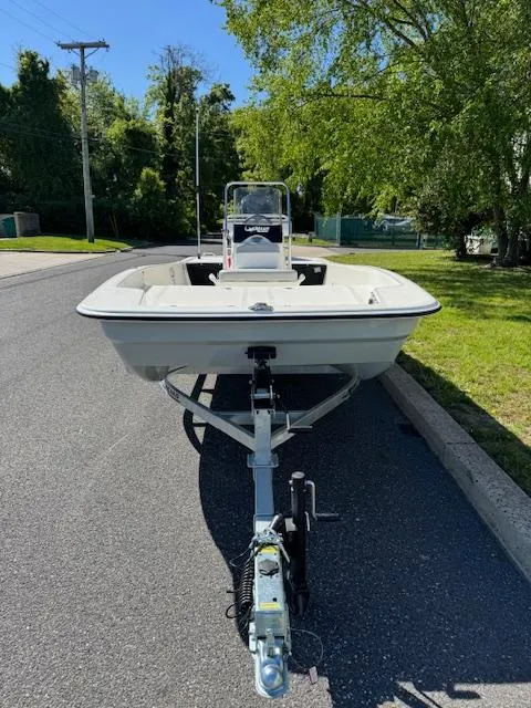 Slide: The Image of 2025 Mako Pro Skiff 17 CC boat on trailer, parked on a sunny street. - 8