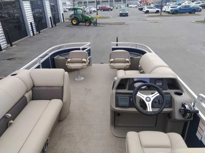 Slide: The Image of 2025 Sun Tracker Fishin' Barge 20 DLX pontoon boat interior with seating and steering console. - 2