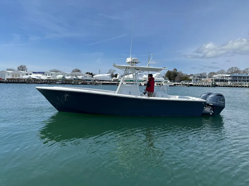 Slide: The Image of 2003 Regulator 26 Center Console boat on calm water, with a person onboard. - 0