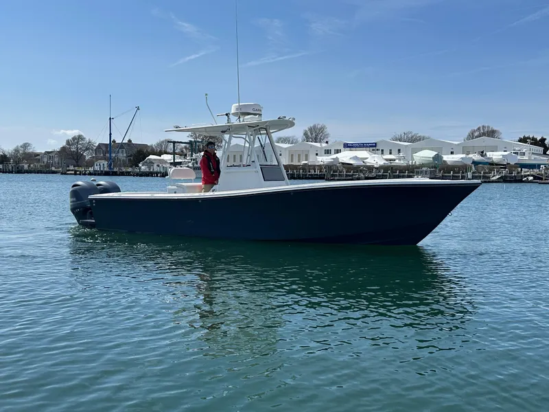Slide: The Image of 2003 Regulator 26 Center Console boat on calm water, with marina in background. - 11