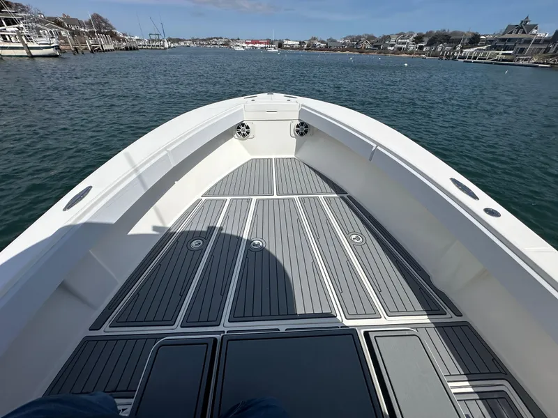 Slide: The Image of 2003 Regulator 26 Center Console boat on calm water, featuring spacious deck and coastal view. - 12