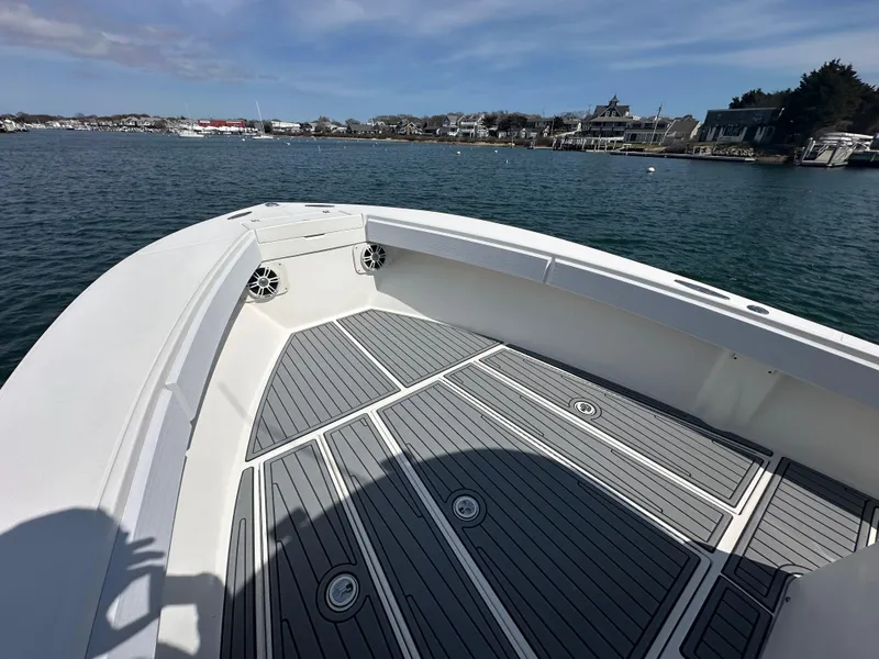 Slide: The Image of 2003 Regulator 26 Center Console boat on calm water, featuring spacious deck and coastal view. - 13