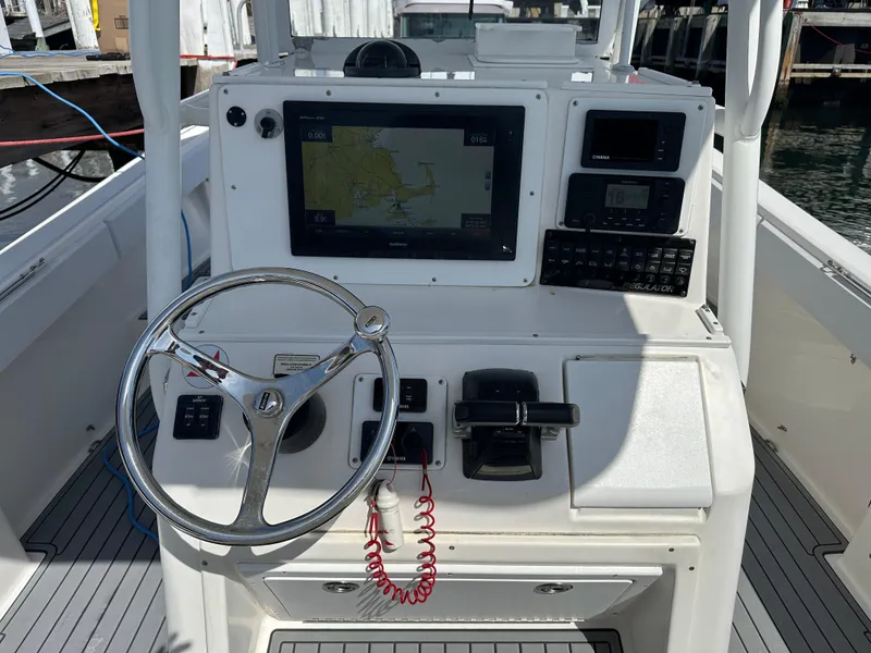 Slide: The Image of 2003 Regulator 26 Center Console boat dashboard with steering wheel and navigation equipment. - 19