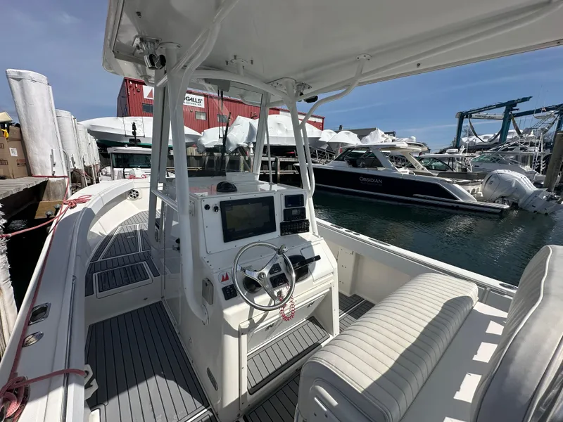 Slide: The Image of 2003 Regulator 26 Center Console boat docked at marina, featuring modern navigation equipment. - 20