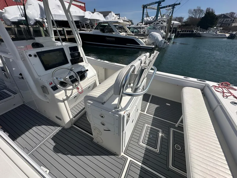 Slide: The Image of 2003 Regulator 26 Center Console boat interior at marina, featuring helm and seating. - 21