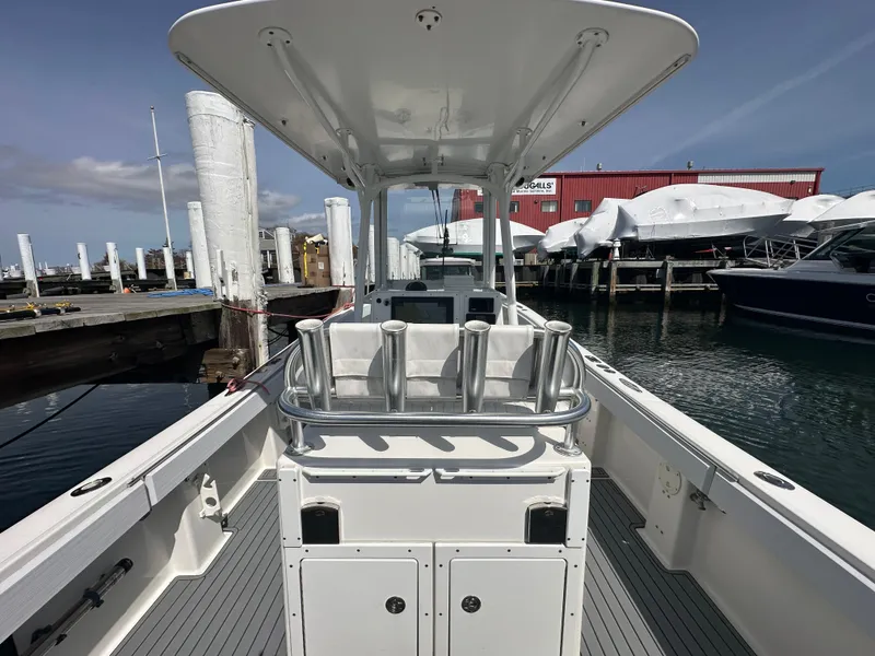 Slide: The Image of 2003 Regulator 26 Center Console boat docked at marina, featuring spacious deck and rod holders. - 22
