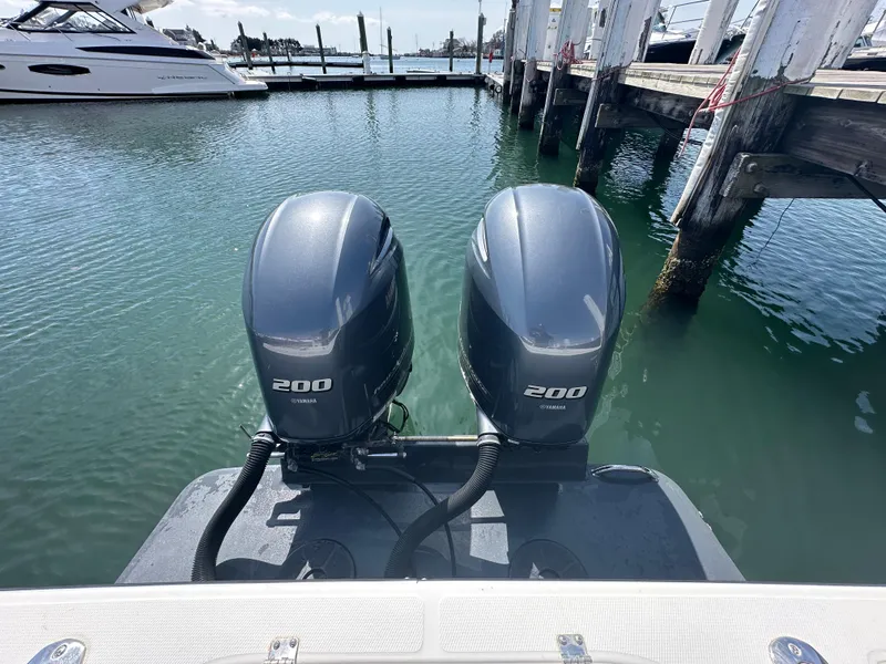 Slide: The Image of Twin Yamaha 200 engines on a 2003 Regulator 26 Center Console boat at a marina. - 23