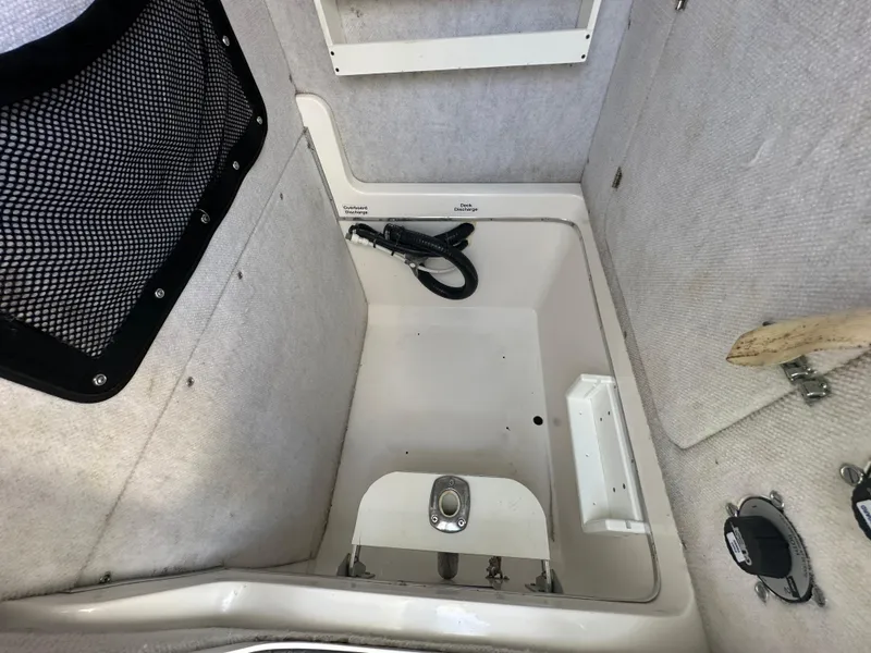 Slide: The Image of 2003 Regulator 26 Center Console interior storage compartment with netting and hose. - 24