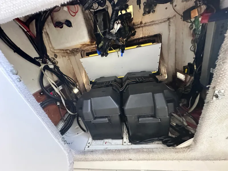 Slide: The Image of 2003 Regulator 26 Center Console battery compartment with wiring and equipment. - 26